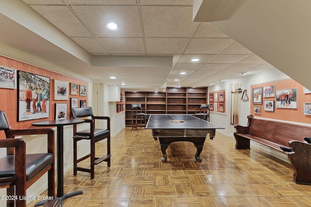 rec room featuring baseboards, wooden walls, and recessed lighting