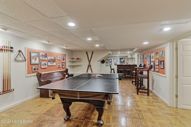 recreation room featuring baseboards, a dry bar, a paneled ceiling, and recessed lighting