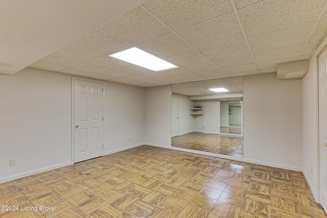 unfurnished room featuring baseboards and a drop ceiling