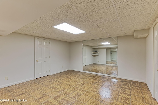 unfurnished room with a drop ceiling and baseboards
