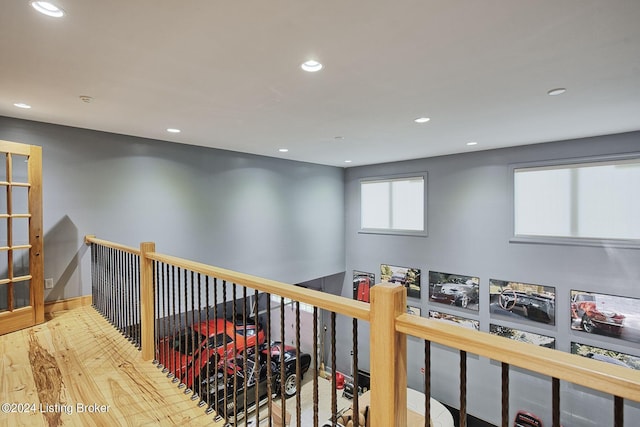 corridor with recessed lighting, baseboards, an upstairs landing, and wood finished floors