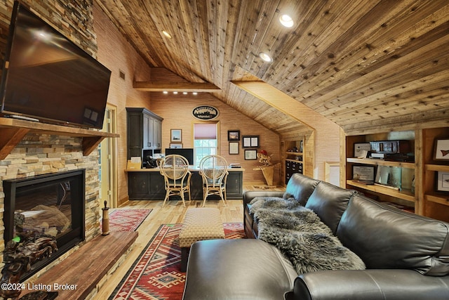 living room featuring a stone fireplace, light wood finished floors, wooden ceiling, and visible vents