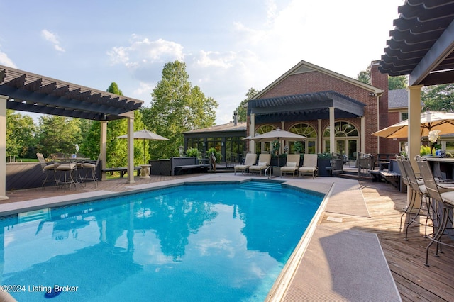 pool with a wooden deck and a pergola