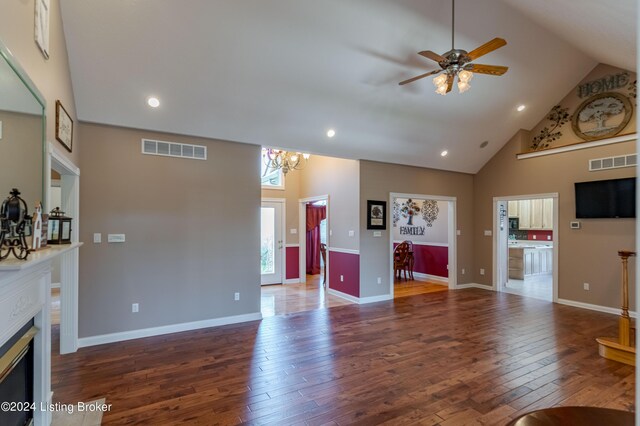 living room featuring ceiling fan with notable chandelier, hardwood / wood-style flooring, and high vaulted ceiling