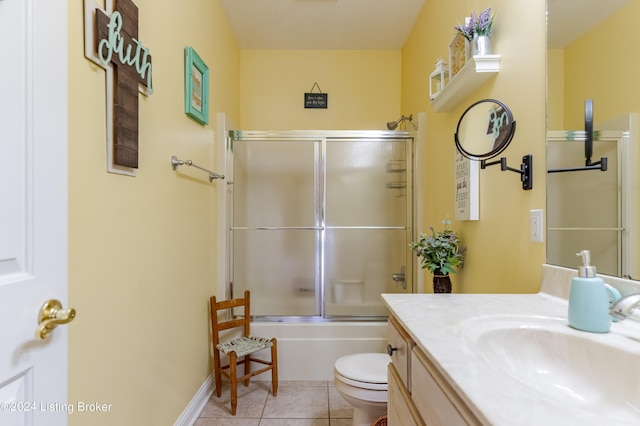 full bathroom featuring combined bath / shower with glass door, vanity, toilet, and tile patterned floors