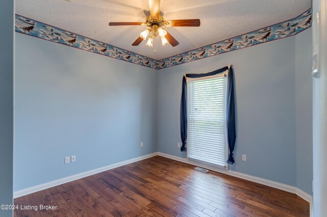 spare room featuring ceiling fan, dark hardwood / wood-style floors, and a textured ceiling