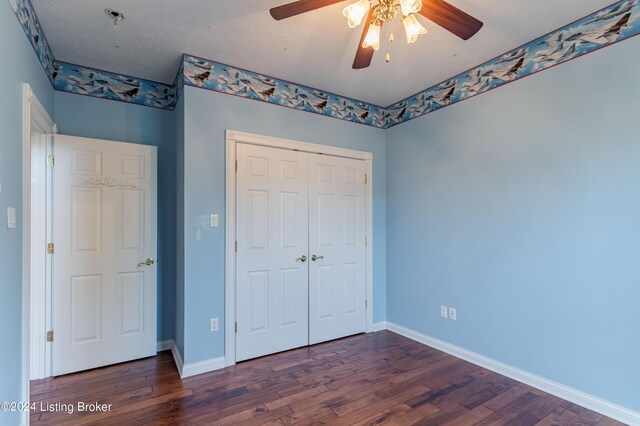 unfurnished bedroom featuring ceiling fan, dark hardwood / wood-style floors, and a closet