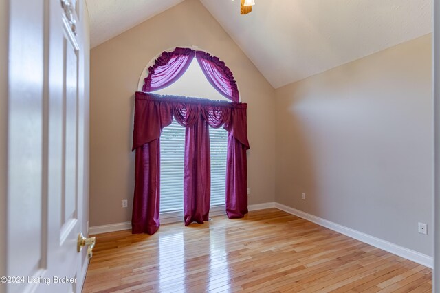 spare room featuring vaulted ceiling and light hardwood / wood-style floors