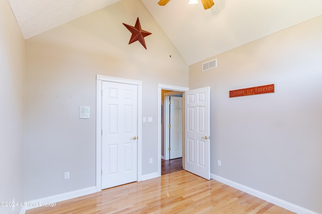 unfurnished bedroom featuring high vaulted ceiling, ceiling fan, and light hardwood / wood-style floors