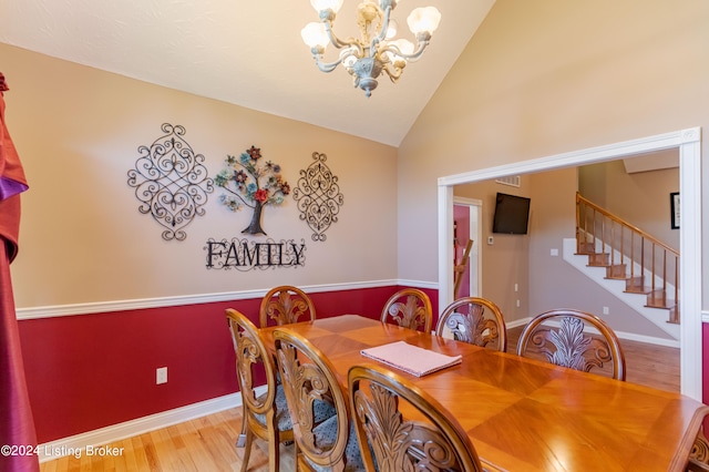 dining area with lofted ceiling, light hardwood / wood-style flooring, and a notable chandelier