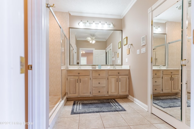 bathroom with a textured ceiling, vanity, tile patterned flooring, tiled shower, and ceiling fan