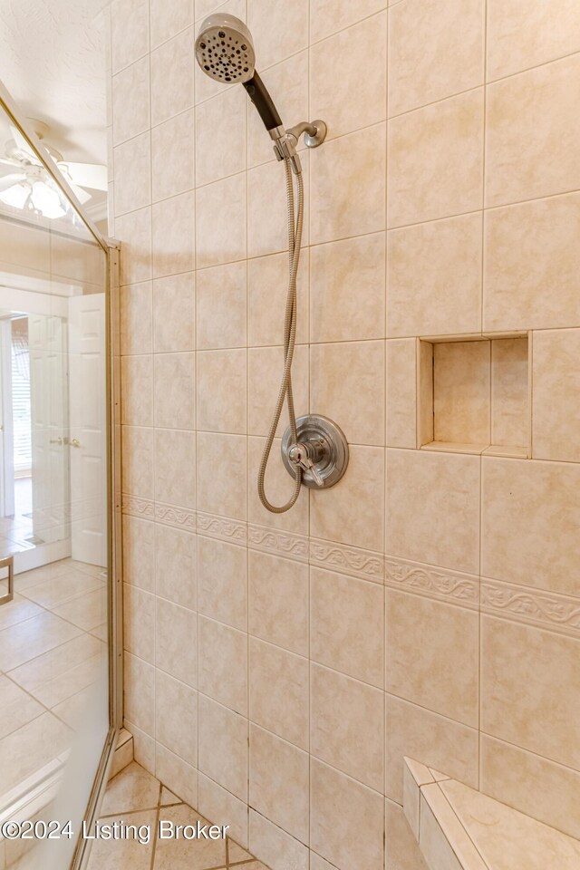 bathroom featuring tiled shower and tile patterned flooring