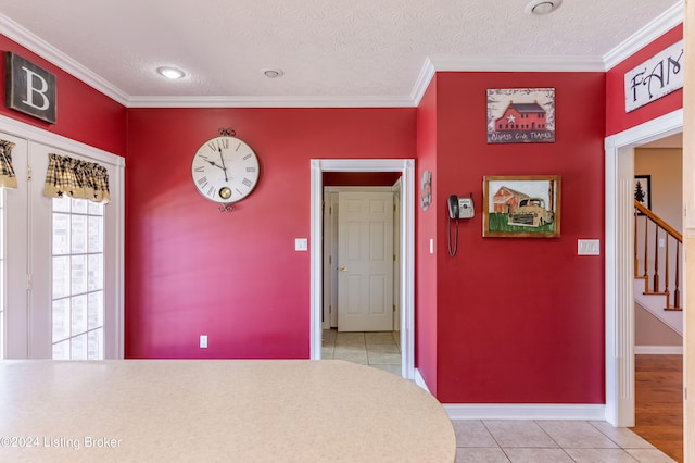 interior space with ornamental molding, a textured ceiling, and light tile patterned floors