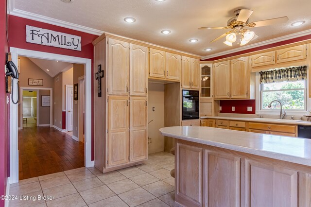 kitchen with light hardwood / wood-style floors, crown molding, sink, ceiling fan, and black oven