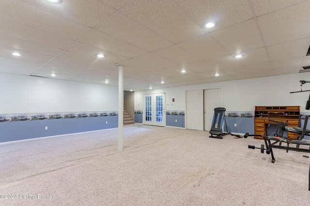 basement featuring a paneled ceiling and carpet floors