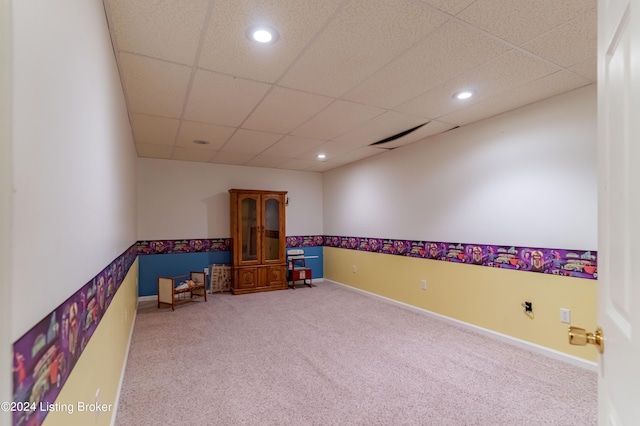 carpeted empty room featuring a paneled ceiling