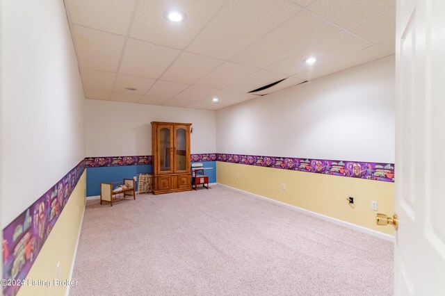 carpeted empty room with a drop ceiling