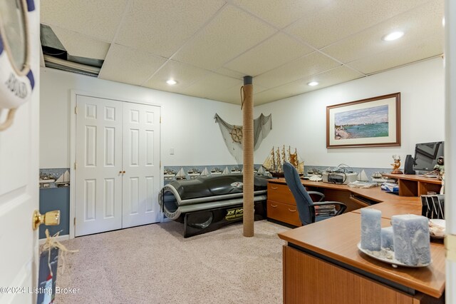 carpeted office space with a drop ceiling