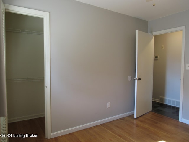 unfurnished bedroom with hardwood / wood-style flooring and a closet