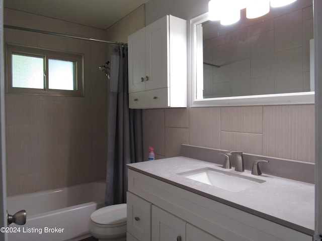 full bathroom with shower / tub combo with curtain, vanity, and toilet