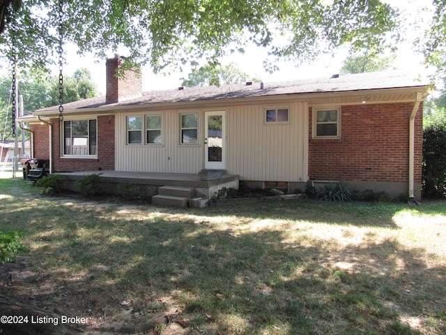 rear view of property featuring a yard