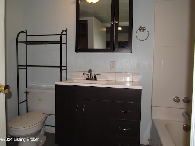 bathroom with a bathtub, vanity, and toilet