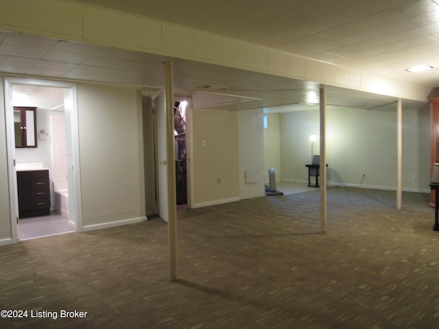 basement with carpet flooring and a paneled ceiling