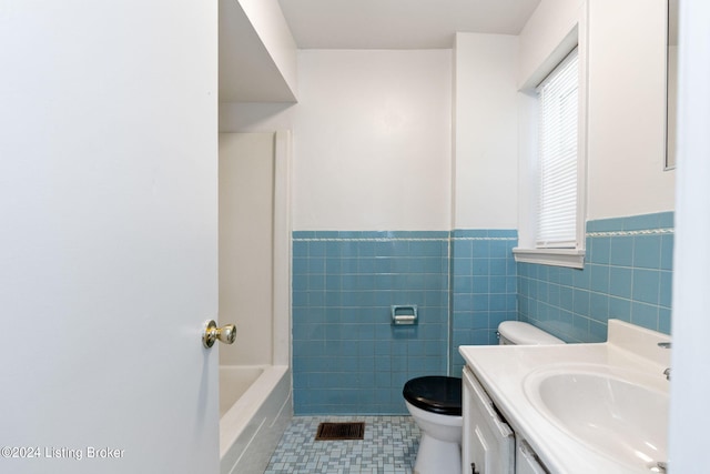 bathroom with vanity, tile walls, tile patterned flooring, and toilet