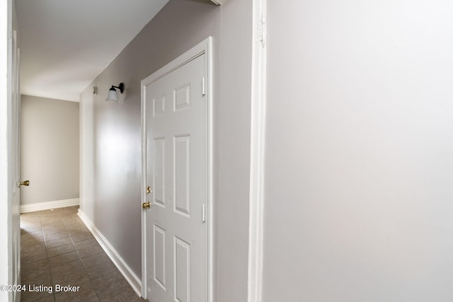 corridor featuring dark tile patterned flooring