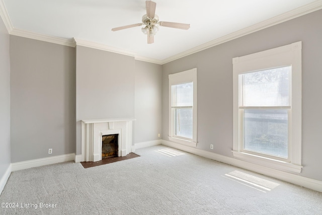 unfurnished living room with ornamental molding, ceiling fan, light colored carpet, and a fireplace