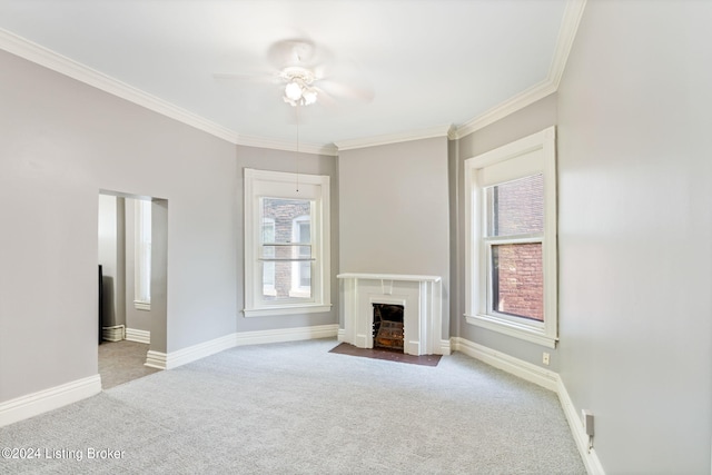 unfurnished living room with light carpet, a wealth of natural light, ceiling fan, and crown molding