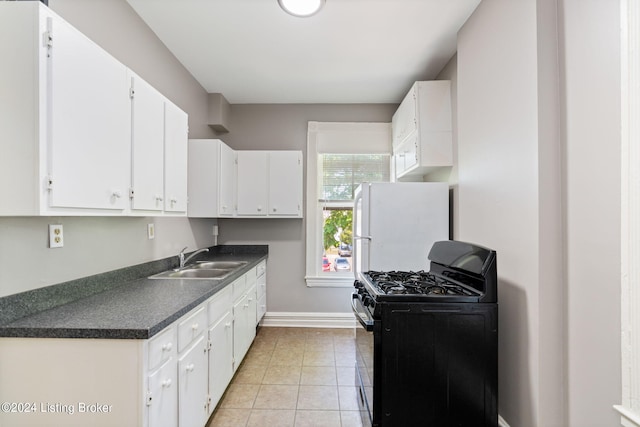 kitchen with white cabinets, white refrigerator, black gas stove, light tile patterned flooring, and sink