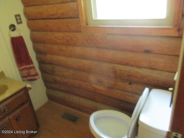 514 Eddie Miles Rd, New Haven, KY 40051 - bathroom featuring visible vents, rustic walls, vanity, and toilet