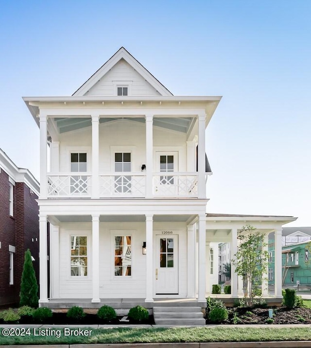 neoclassical / greek revival house featuring a balcony and covered porch