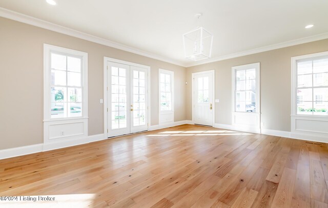 interior space with french doors, crown molding, and light hardwood / wood-style flooring