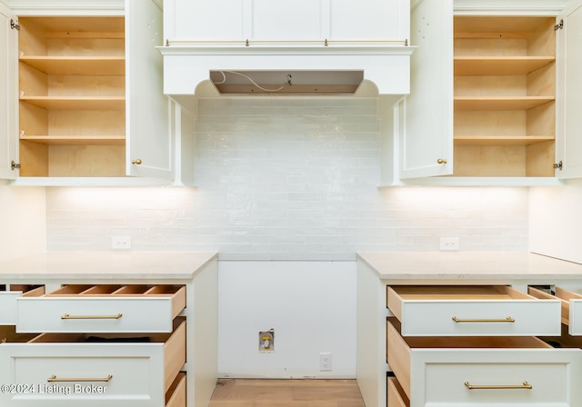 kitchen with light hardwood / wood-style flooring, white cabinets, and tasteful backsplash