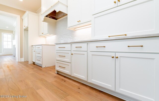 kitchen with backsplash, white cabinets, and light hardwood / wood-style floors