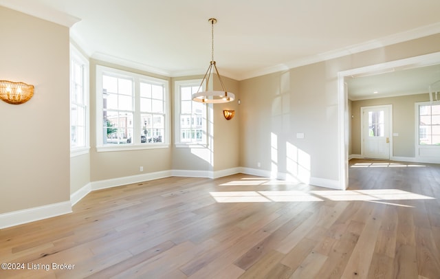 unfurnished dining area with crown molding, light hardwood / wood-style flooring, and a notable chandelier