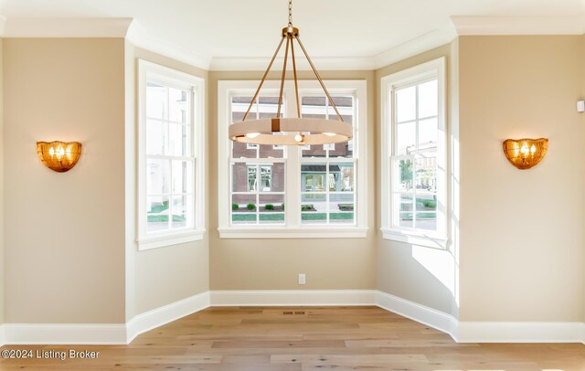 unfurnished dining area with a wealth of natural light, light hardwood / wood-style floors, and crown molding