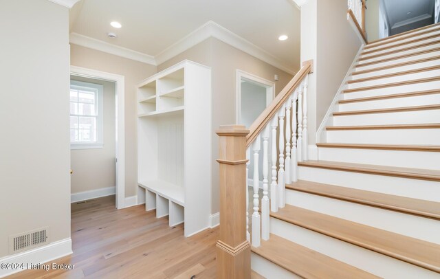 stairway featuring crown molding and wood-type flooring