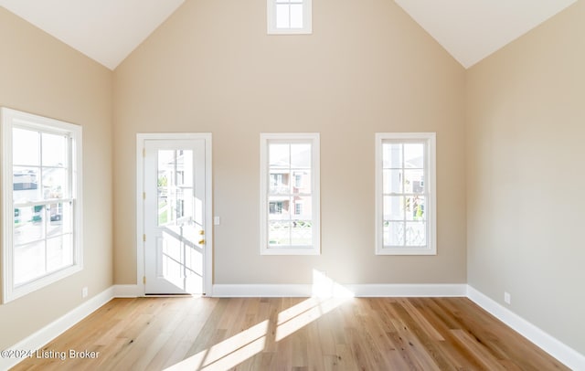 entryway featuring high vaulted ceiling, a wealth of natural light, and light hardwood / wood-style floors