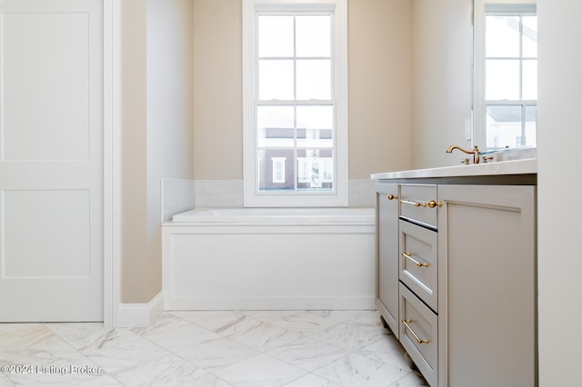 bathroom featuring vanity, a healthy amount of sunlight, and a bathtub