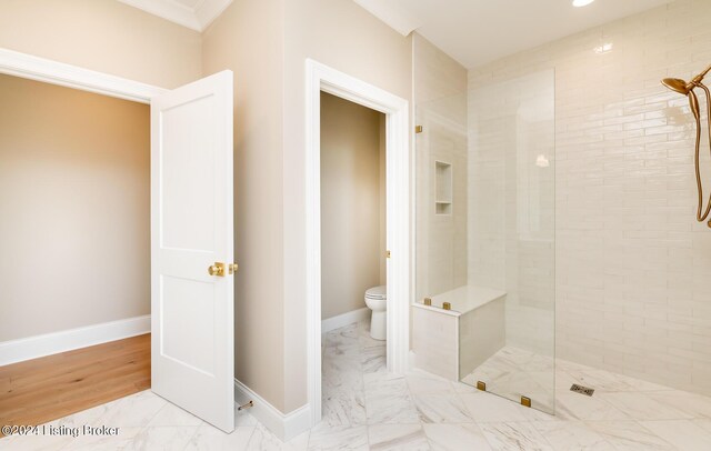 bathroom featuring toilet and tiled shower