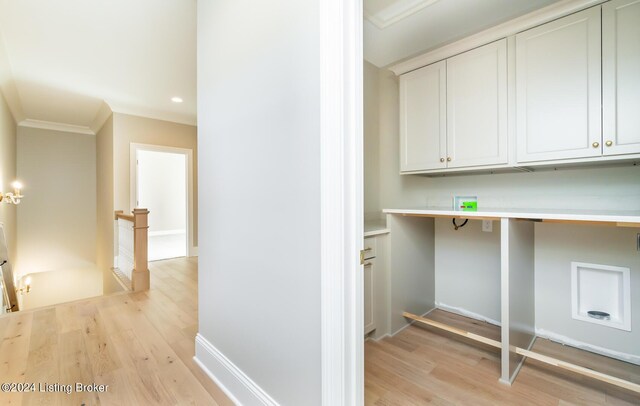 interior space with light wood-type flooring, cabinets, and ornamental molding