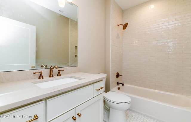 full bathroom featuring tile patterned flooring, tiled shower / bath, toilet, and vanity