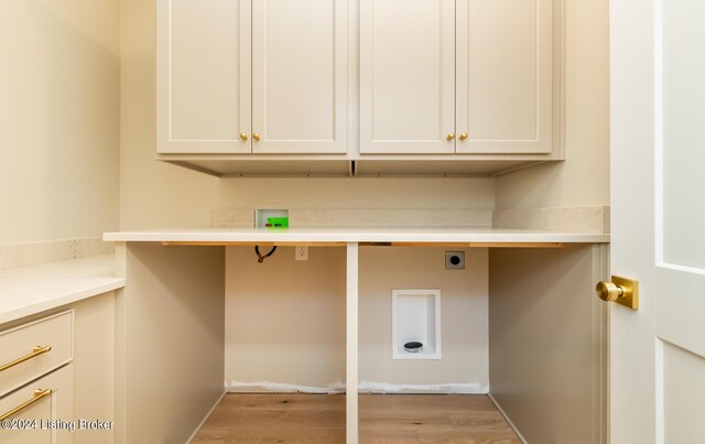 clothes washing area featuring cabinets, electric dryer hookup, washer hookup, and light hardwood / wood-style floors