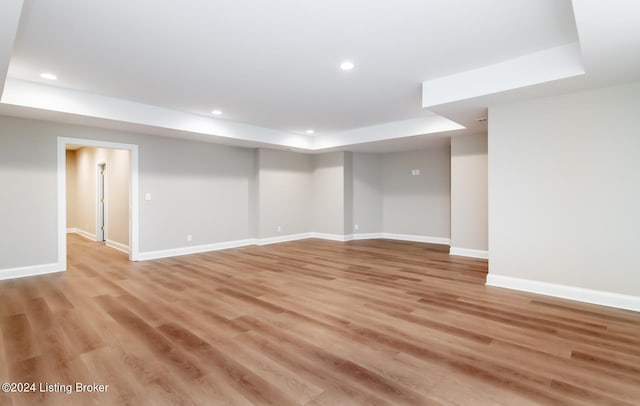 interior space featuring a raised ceiling and light hardwood / wood-style floors