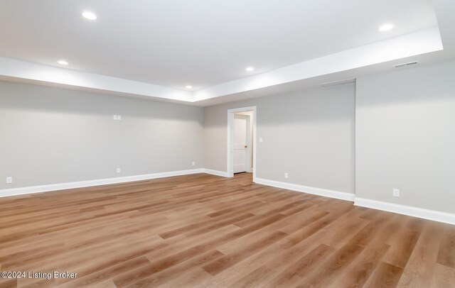 interior space featuring a raised ceiling and hardwood / wood-style flooring