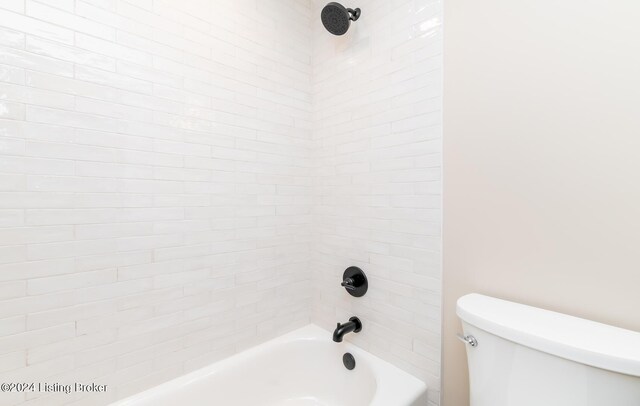 bathroom with toilet and tiled shower / bath combo