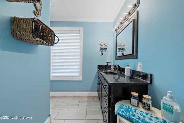 bathroom with ornamental molding, vanity, and baseboards